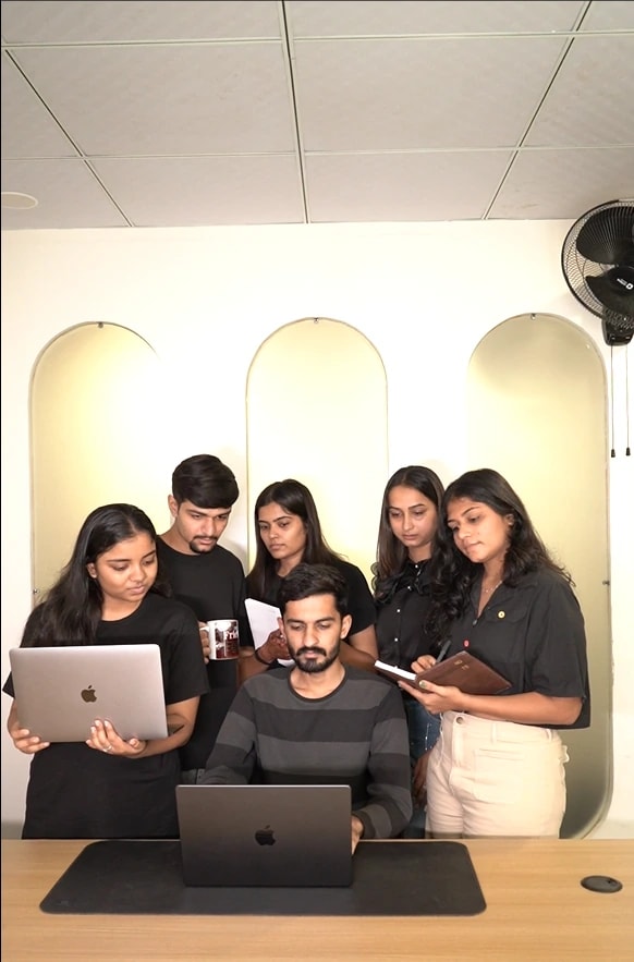 The Kalaa team gathered around a laptop in the office