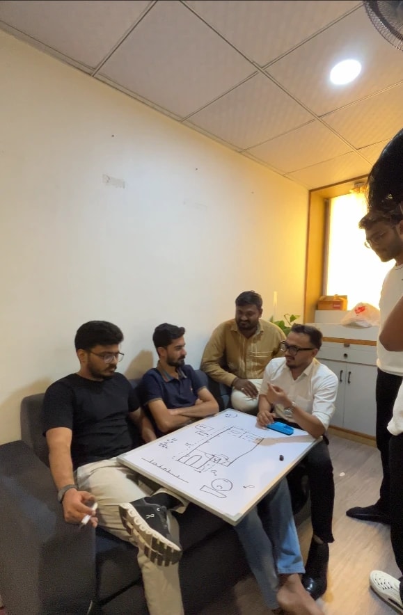 Kalaa team members planning around a whiteboard sketch